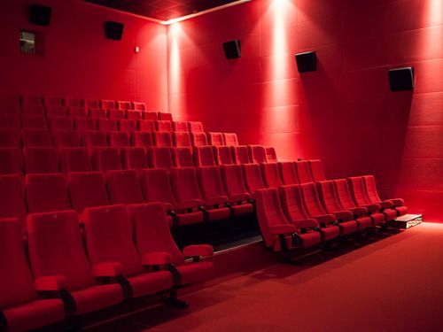 a red theater with rows of empty seats