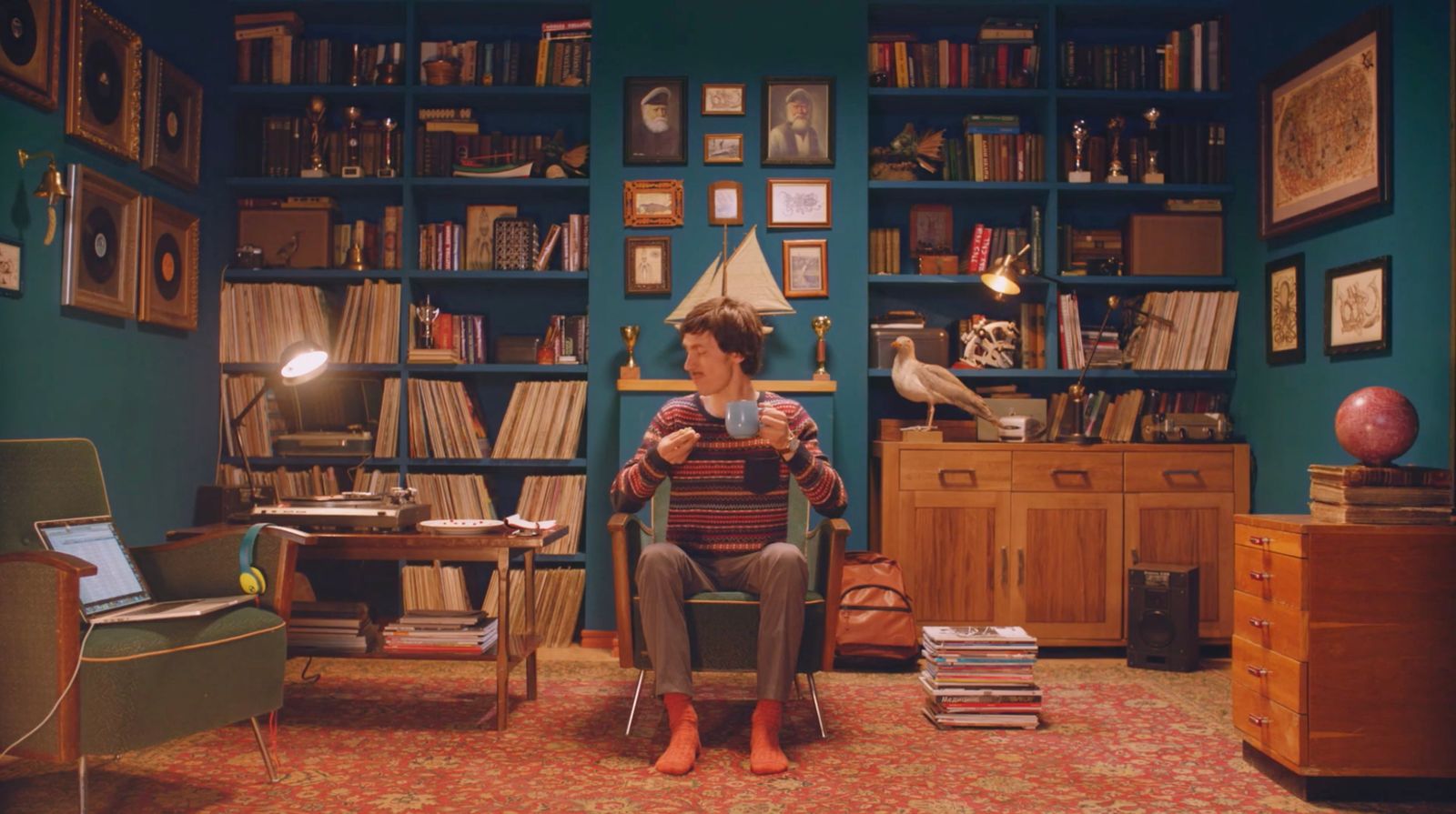 a woman sitting in a chair in front of a bookshelf