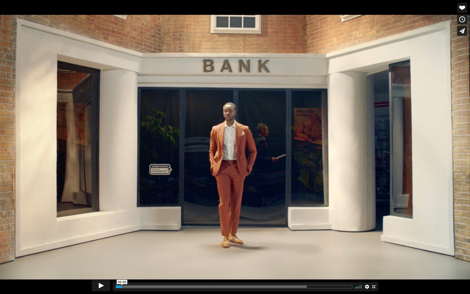 a man in an orange suit is standing in front of a bank