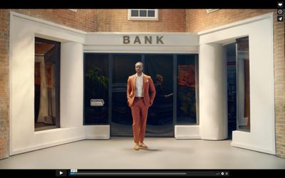 a man in an orange suit is standing in front of a bank