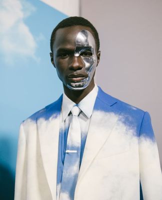 a man in a blue and white suit with a silver mask on his face