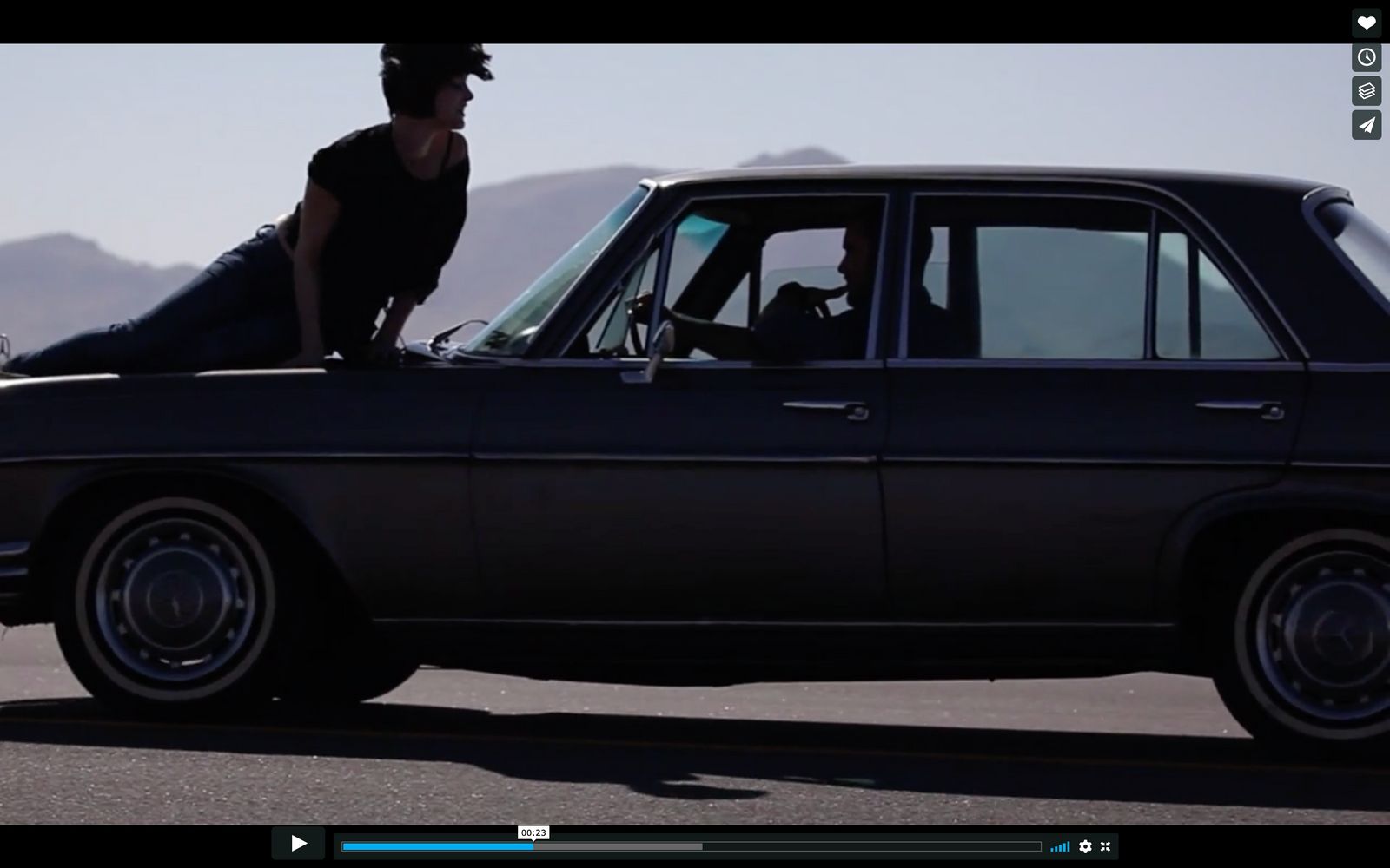 a woman sitting on the hood of a car