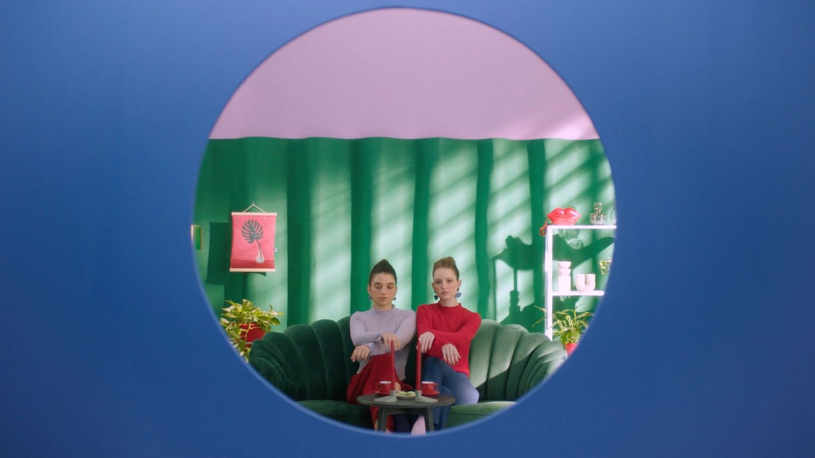 a couple of women sitting on top of a green couch