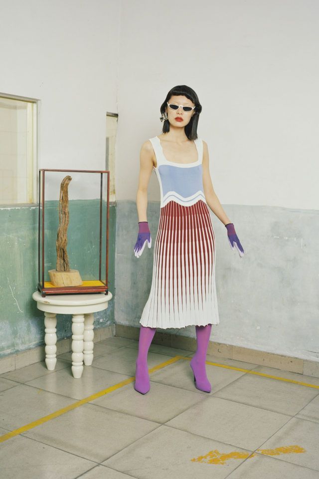 a woman in a white dress and purple gloves