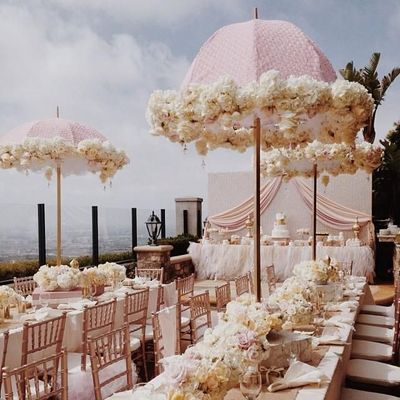 a table set up with flowers and umbrellas