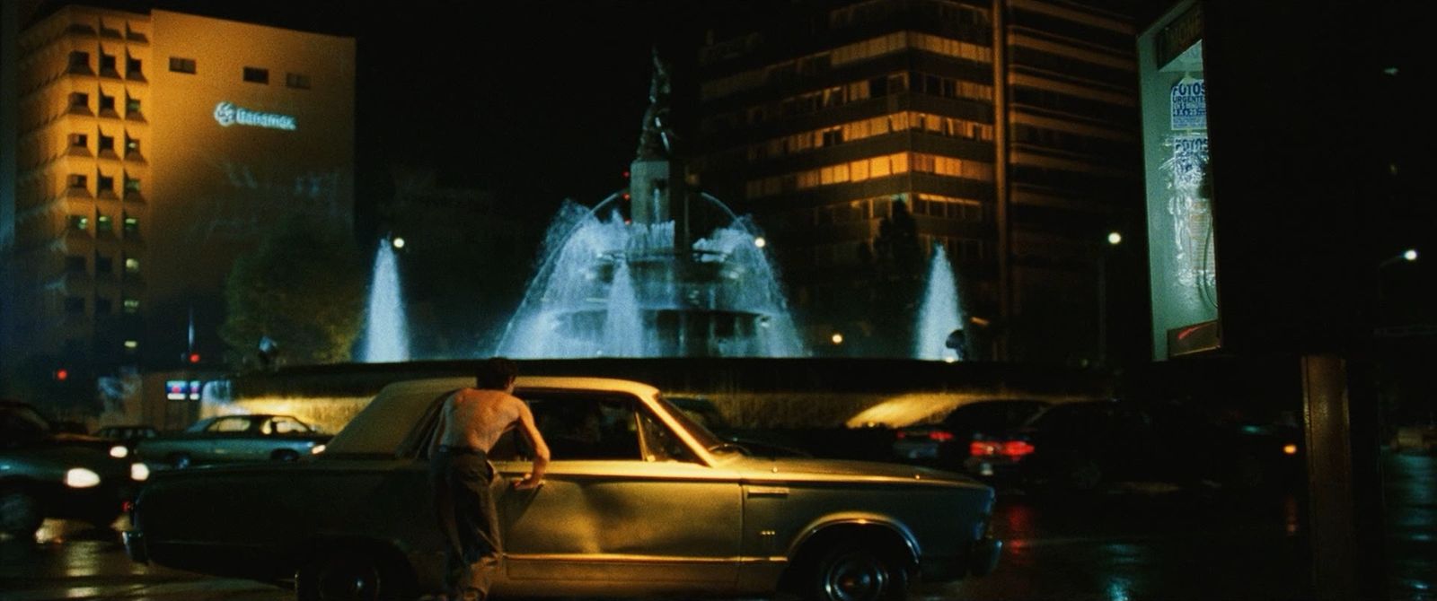 a man standing in front of a fountain at night