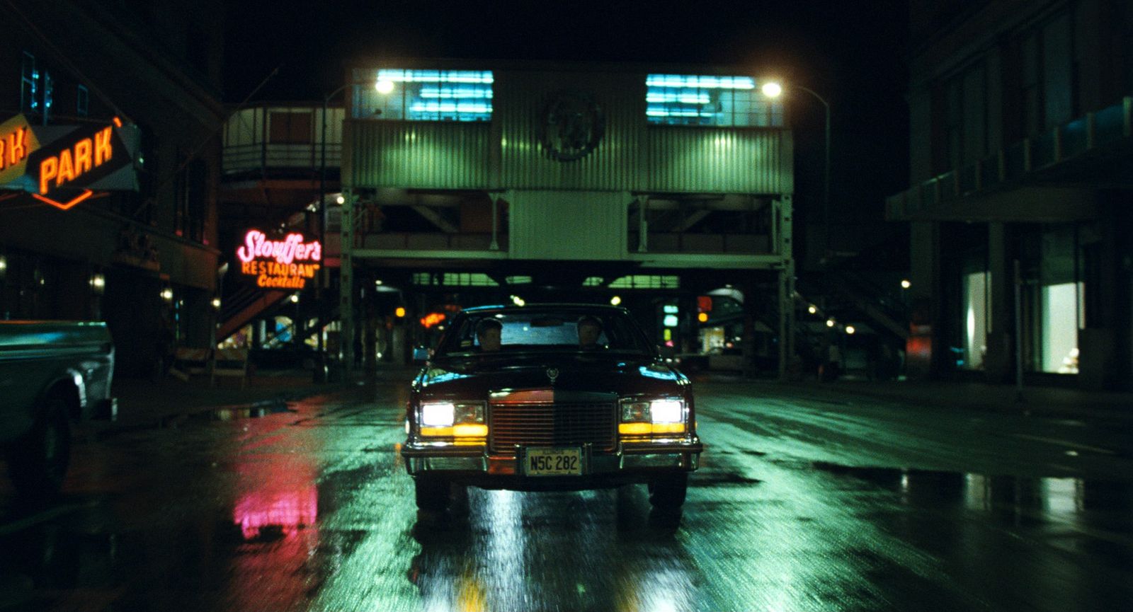 a car driving down a wet street at night