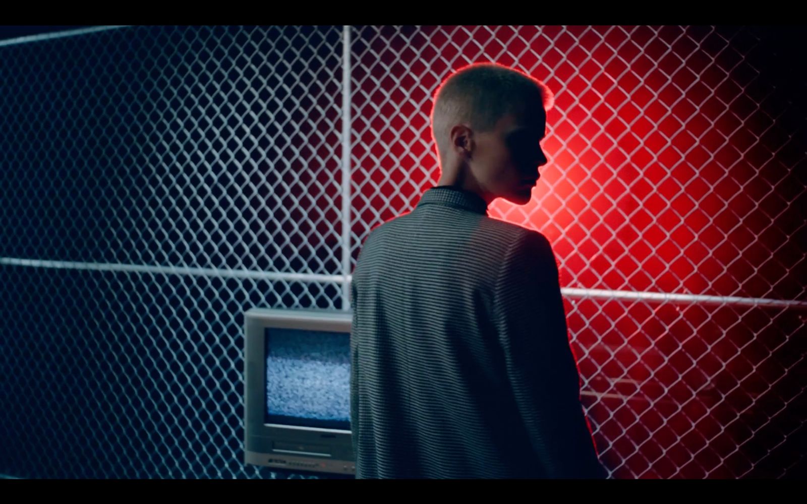 a man standing in front of a tv in a dark room