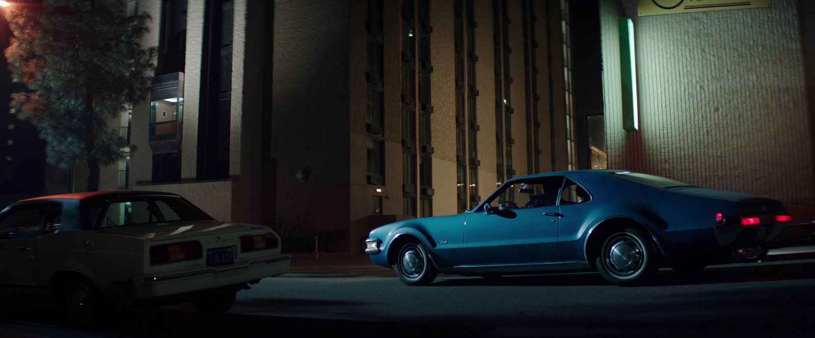 two cars parked on the side of the road at night