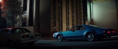 two cars parked on the side of the road at night