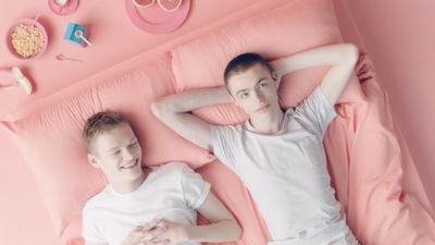 a couple of people laying on top of a pink bed