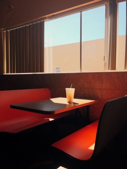 a table with a drink on it next to a window