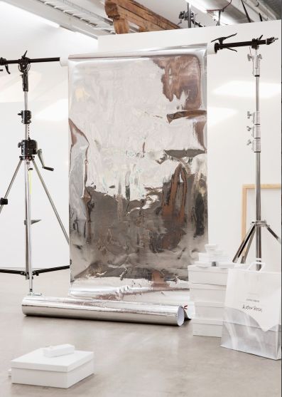 a photo studio with a large mirror on the wall