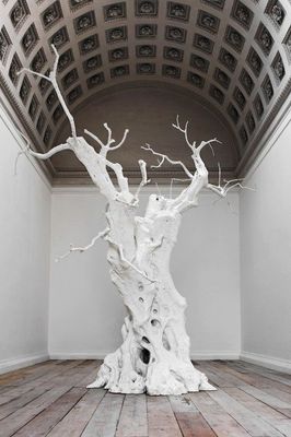 a white sculpture of a tree in a room