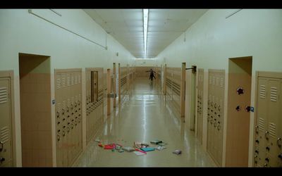 a hallway with several lockers and a person in the distance