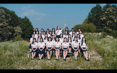 a group of women sitting next to each other in a field