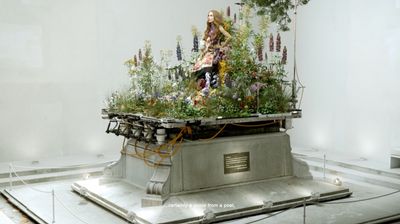 a sculpture of a woman surrounded by flowers