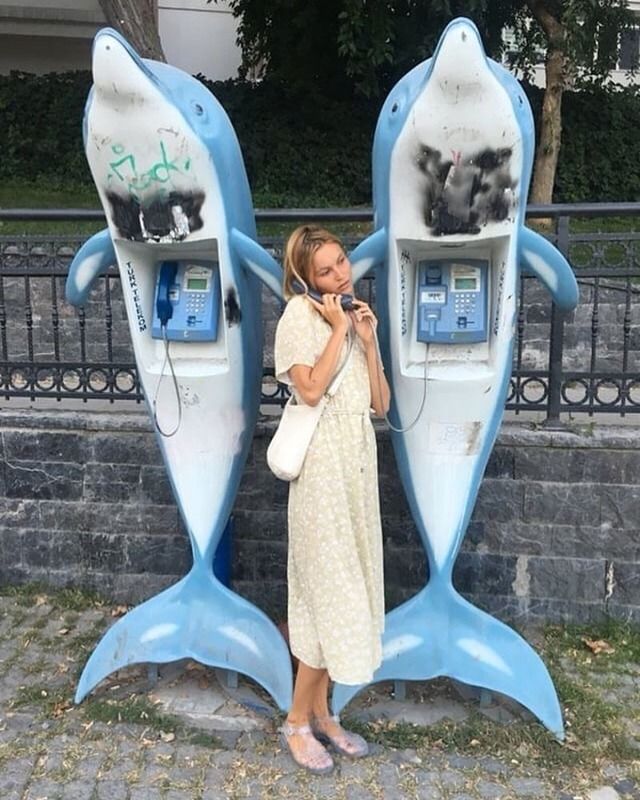 a woman standing in front of a phone booth