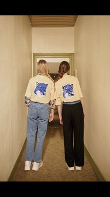 two women are walking down a hallway together