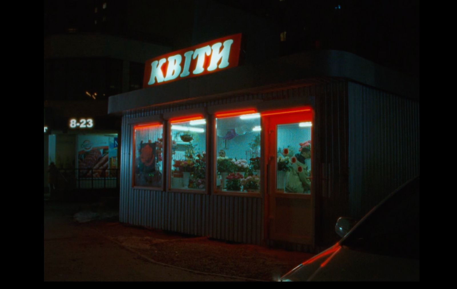 a store front at night lit up with red lights