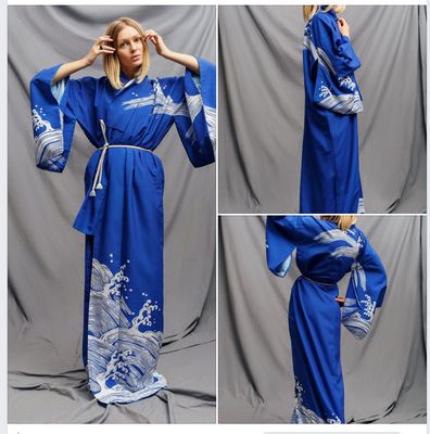 a woman in a blue kimono is posing for a picture