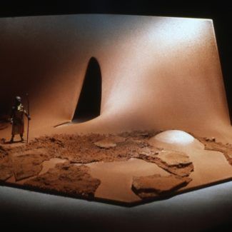 a model of a desert with a man standing next to it