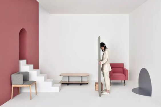 a woman standing in a room with a red chair