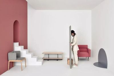 a woman standing in a room with a red chair