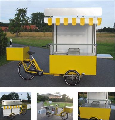 a yellow bike is parked next to a food cart