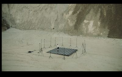 a group of cell phones sitting on top of a sandy ground