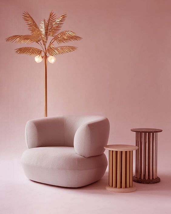 a pink room with a white chair and a palm tree