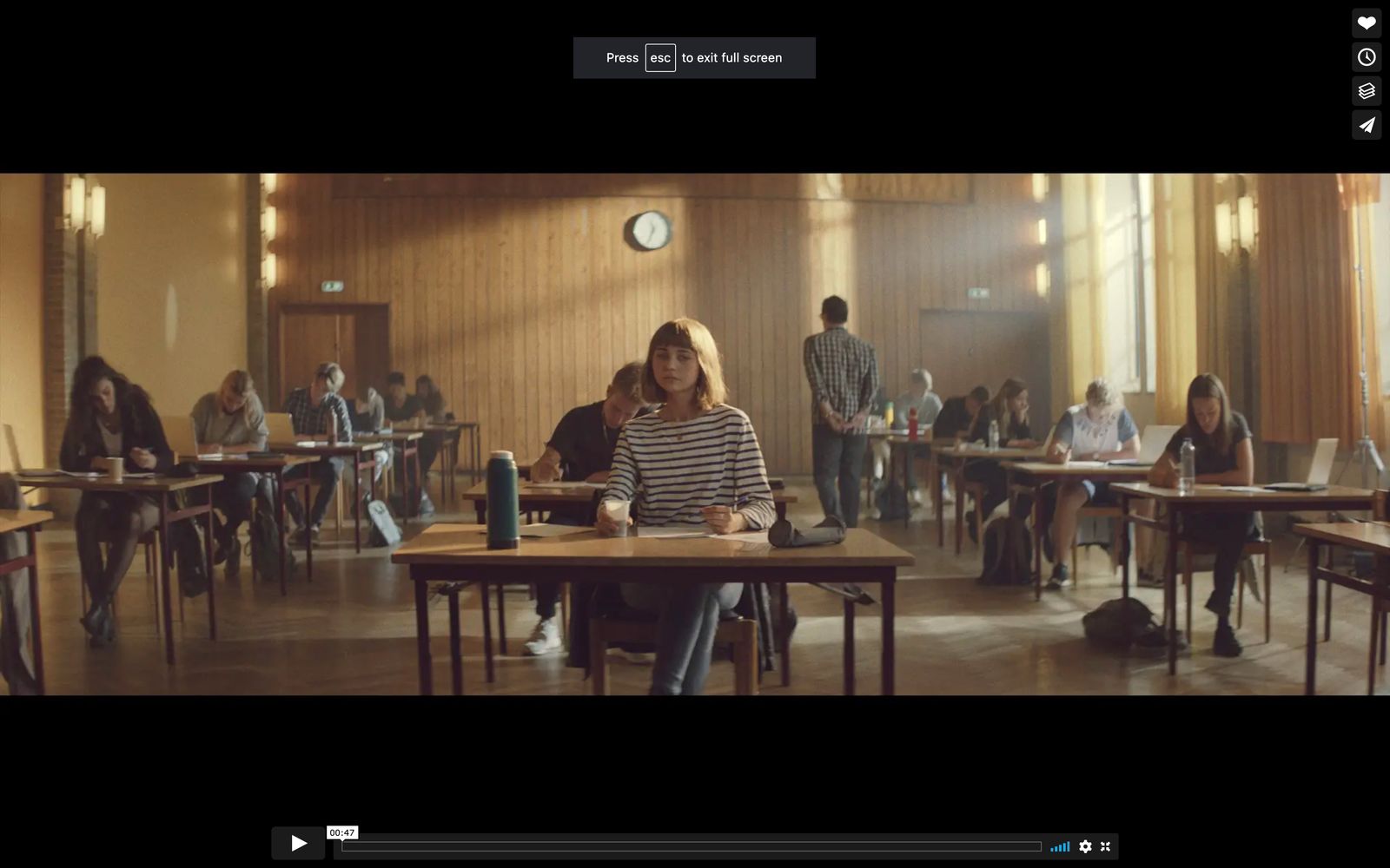 a group of people sitting at desks in a room