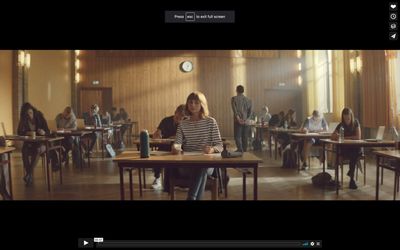 a group of people sitting at desks in a room