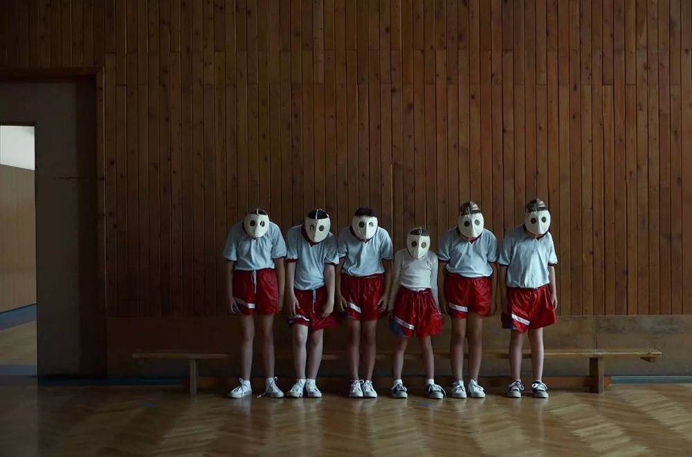 a group of people standing in front of a wooden wall