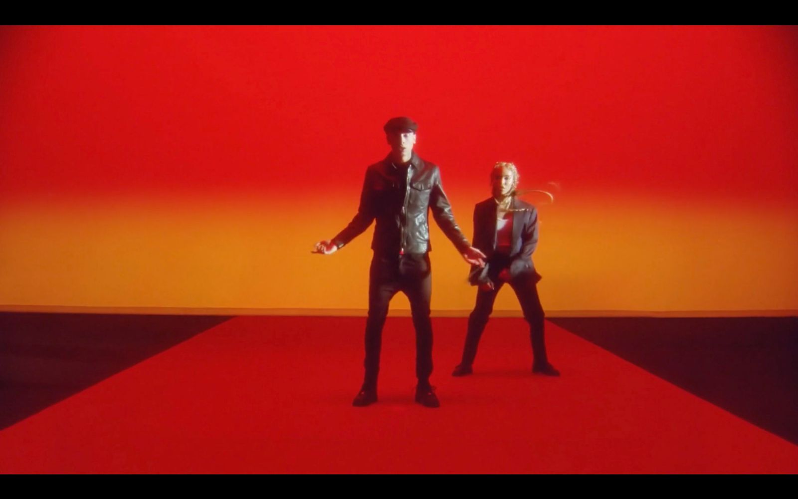 a couple of people standing on top of a red carpet