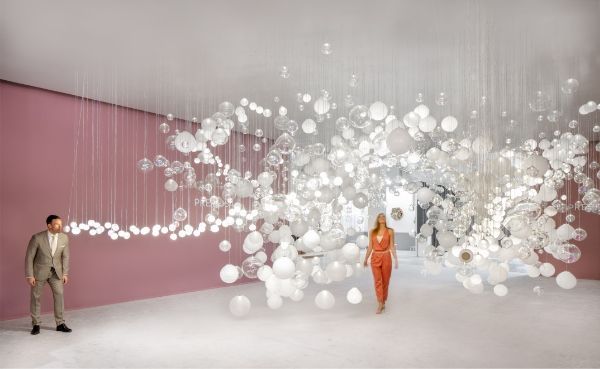 a man and a woman are standing in a room with bubbles floating from the ceiling