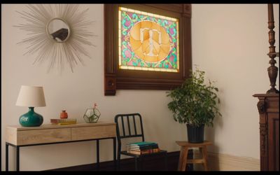 a room with a desk, chair, and a stained glass window