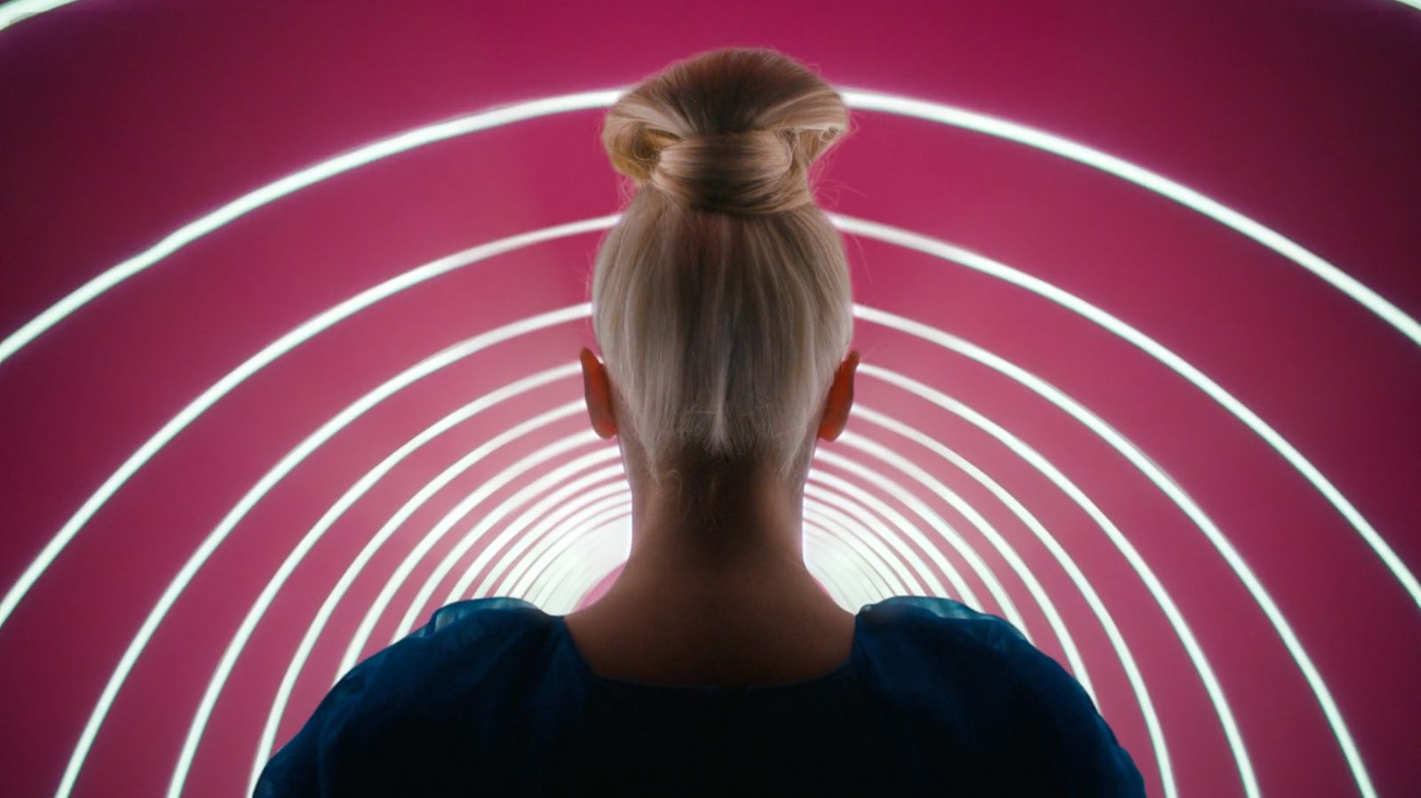 a woman standing in front of a tunnel of light