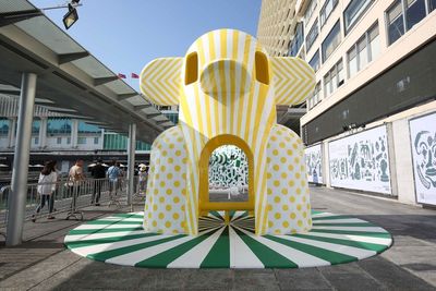 a large yellow and white sculpture in the middle of a street