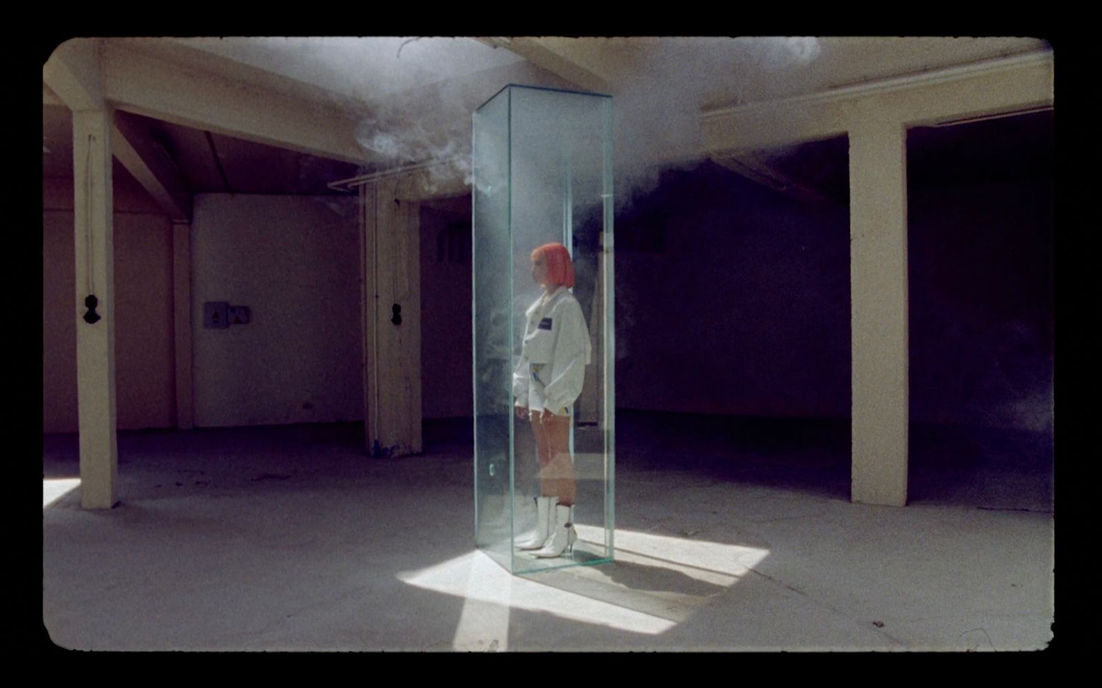 a man standing in a tall glass container with steam coming out of it