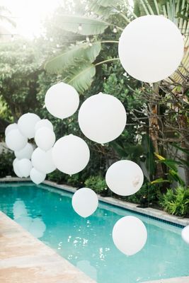 a pool with white balloons floating from it