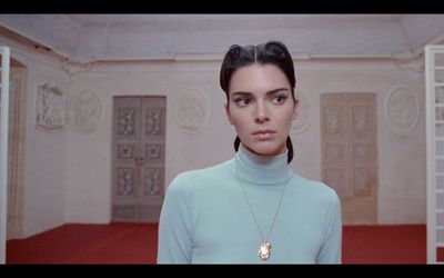 a woman in a blue turtle neck sweater standing in a room