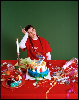 a woman sitting at a table with a birthday cake