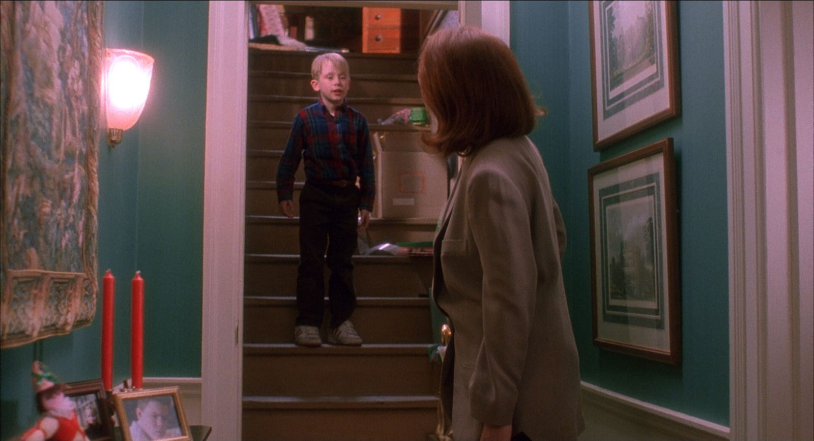 a woman standing next to a little boy on the stairs