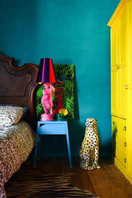 a bedroom with a blue wall and a yellow dresser