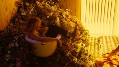 a woman sitting in a bathtub surrounded by flowers