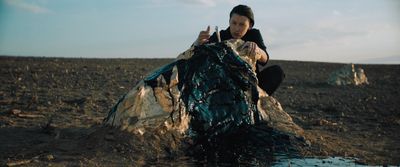 a woman sitting on top of a pile of dirt