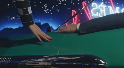 a woman's hand on the hood of a green car