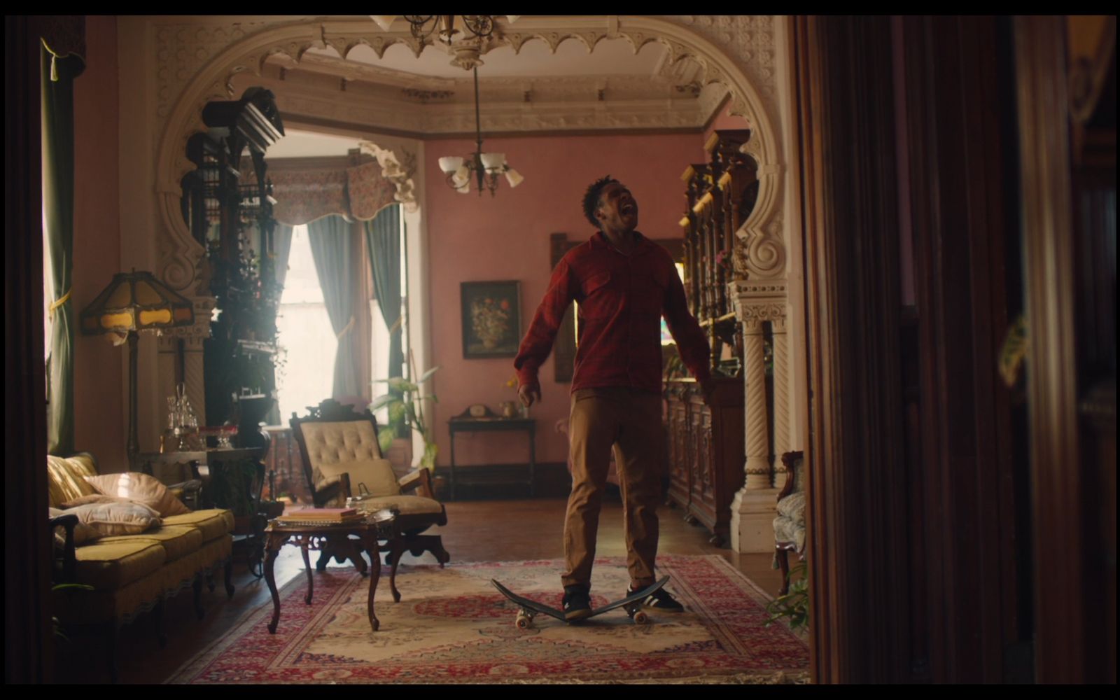 a man standing on a skateboard in a living room