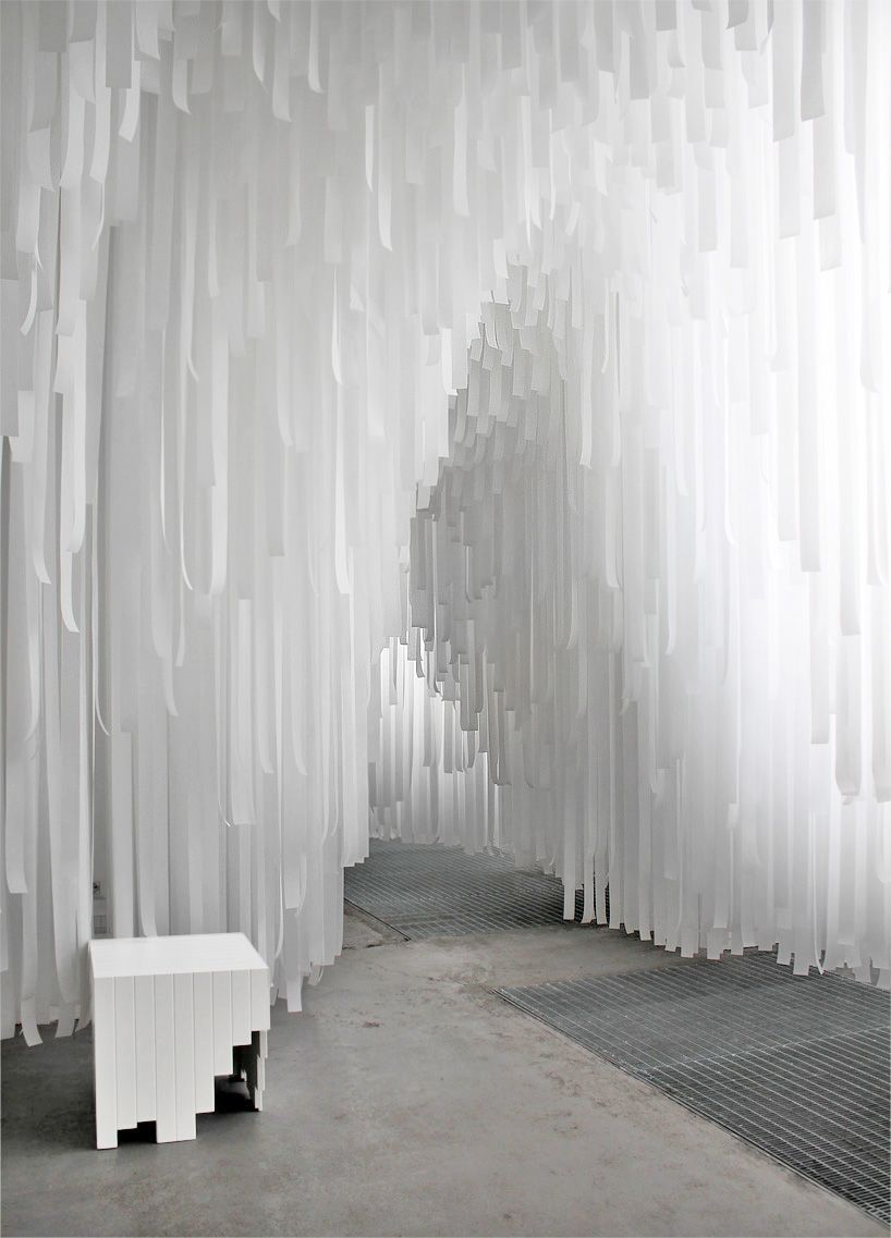 a white bench sitting in front of a white curtain